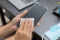 woman hand is wiped clean mobile phone with a cloth and alcohol to kill harmful virus, germs Royalty Free Stock Photo