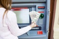 Woman hand withdrawing money from outdoor bank ATM