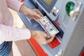 Woman hand withdrawing money from outdoor bank ATM