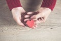 Woman hand wooden red heart