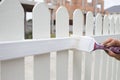 Woman hand worker painting white fence Royalty Free Stock Photo