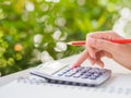 Woman hand working with calculator and holding red pencil Royalty Free Stock Photo