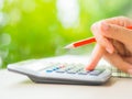 Woman hand working with calculator and holding red pencil Royalty Free Stock Photo