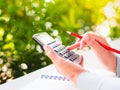 Woman hand working with calculator and holding red pencil Royalty Free Stock Photo