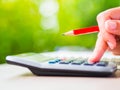 Woman hand working with calculator and holding red pencil Royalty Free Stock Photo