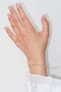 Woman hand and wrist wearing golden zircon sparkle bracelet set against a white background Royalty Free Stock Photo