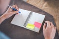 Woman hand is writing on a blank notepad with a pen, on a brown Royalty Free Stock Photo