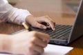 Woman hand writing a contract with a laptop beside Royalty Free Stock Photo