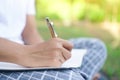 Woman hand writing down in small white memo notebook for take a note not to forget or to do list plan Royalty Free Stock Photo