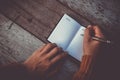 Woman hand writing down in small white memo notebook. Royalty Free Stock Photo