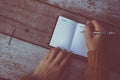 Woman hand writing down in small white memo notebook. Royalty Free Stock Photo