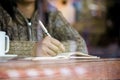 Woman hand writing on notebook in the cafe in rainy day Royalty Free Stock Photo