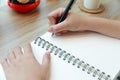 Woman hand writing on notebook paper with a pen on wooden desk i Royalty Free Stock Photo