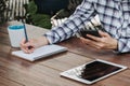 Woman hand writing notepad and holding phone on wooden table at coffee shop Royalty Free Stock Photo