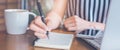 Woman hand is writing on a notepad with a pen on a wooden desk Royalty Free Stock Photo