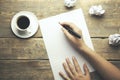 Woman hand writing with pen on notebook and coffee cup on wood table background Royalty Free Stock Photo