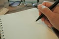 Woman hand is writing on white notebook. Royalty Free Stock Photo