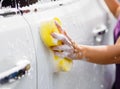 Woman hand with yellow sponge washing car Royalty Free Stock Photo