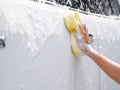 Woman hand with yellow sponge washing car Royalty Free Stock Photo