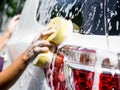 Woman hand with yellow sponge washing car Royalty Free Stock Photo