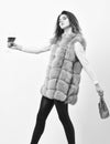 Woman with handbag hold glass of wine. Girl wear fashion fur vest while posing with bag. Luxury store concept. Lady Royalty Free Stock Photo