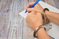 Woman in handcuffs. To sign a guilty verdict. The conviction and prison sentence. Royalty Free Stock Photo