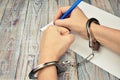Woman in handcuffs. To sign a guilty verdict. The conviction and prison sentence. Royalty Free Stock Photo
