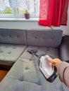 Woman with handheld vacuum cleaning on sofa Royalty Free Stock Photo