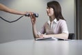 Woman handing over phone receiver to colleague at desk