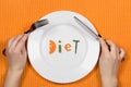 Woman hands above the plate with word diet made of pieces of veg