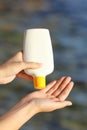 Woman hands applying sunscreen from a sunblock bottle