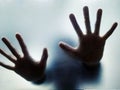 Woman hands behind sandblasted glass.