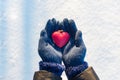 Woman hands in blue gloves holding red heart. Winter valentines day time Royalty Free Stock Photo