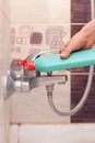 Woman hands with bottle of cleaning detergent for bathroom applies a scour to the metal water tap