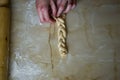Woman, female hands braiding dough on kitchen table. Top view Royalty Free Stock Photo