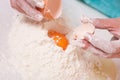 Woman hands breaking egg into flour Royalty Free Stock Photo