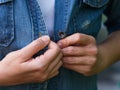 Woman hands buttoning a denim jacket