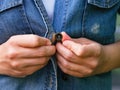 A woman hands buttoning a denim jacket