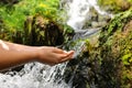 Woman hands catching water from creek