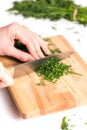 Woman hands chopping the dill on the cutting board Royalty Free Stock Photo