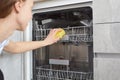 Woman hands cleaning dishwasher panel with yellow rag in kitchen. Close up. Royalty Free Stock Photo