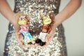 Woman hands close up holding christmas decoration baubles, little dancing frogs