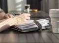 Woman hands closeup writing with pen in notebook or planner, taking notes in cafe with takeaway, silicon cup Royalty Free Stock Photo