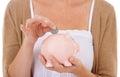 Woman, hands and coin in piggy bank for savings, investment or financial growth on a white studio background. Closeup of Royalty Free Stock Photo