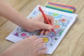 Woman hands coloring patterns on a coloring page for stress rel