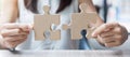 Woman hands connecting couple puzzle over table, businesswoman holding wood jigsaw inside office. Business solutions, mission, Royalty Free Stock Photo