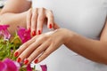Woman Hands With Cream. Closeup Of Beautiful Female Hands With Red Manicure Nails Applying Cosmetic Lotion On Healthy Soft Skin, Royalty Free Stock Photo