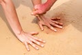 Woman hands creating shapes with red sand on the beach in aboriginal art style Royalty Free Stock Photo