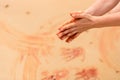 Woman hands creating shapes with red sand on the beach in aboriginal art style Royalty Free Stock Photo