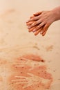 Woman hands creating shapes with red sand on the beach in aboriginal art style Royalty Free Stock Photo